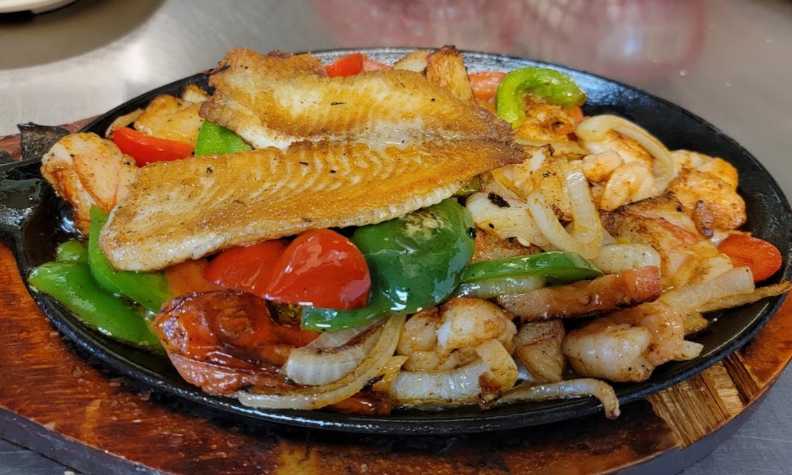 Sizzling platter with fish, shrimp, peppers and onions from Taqueria Jalisco